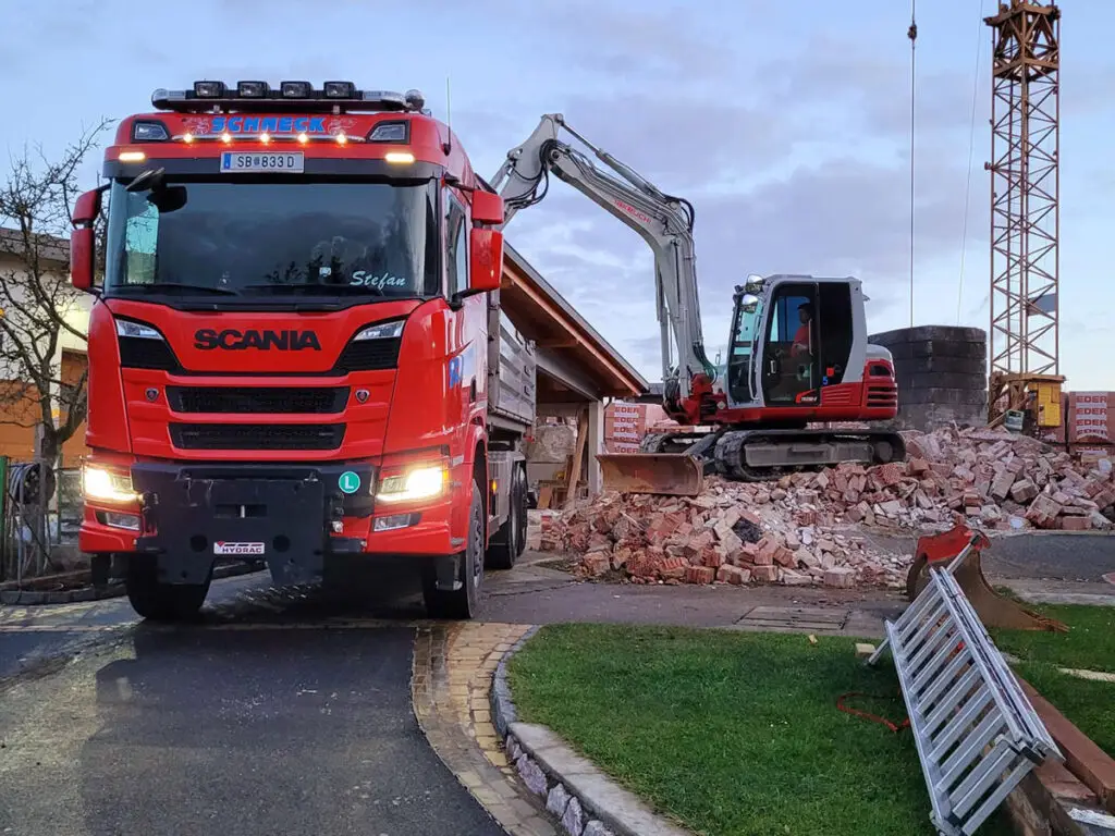 Abtransport von Abbruchmaterial mit LKW während laufender Rückbauarbeiten.