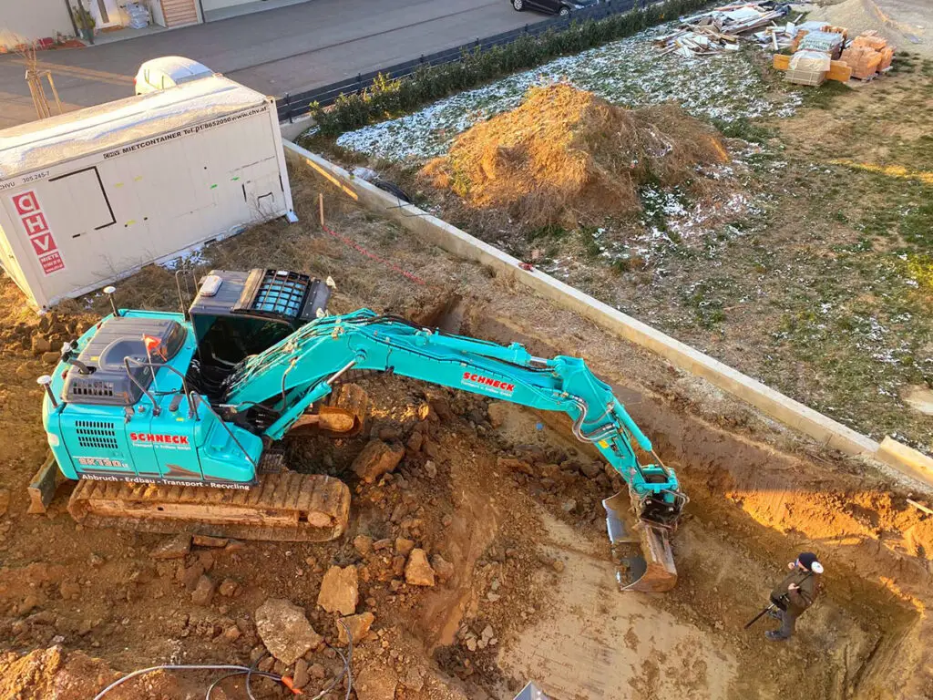 Großflächiger Erdaushub für den Neubau eines Gebäudes mit Kettenbagger.