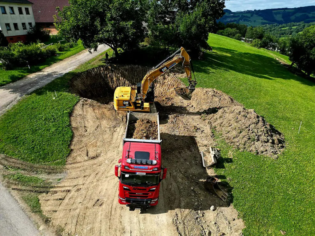 Großflächige Erdarbeiten und Aushubarbeiten mit mehreren Baumaschinen.