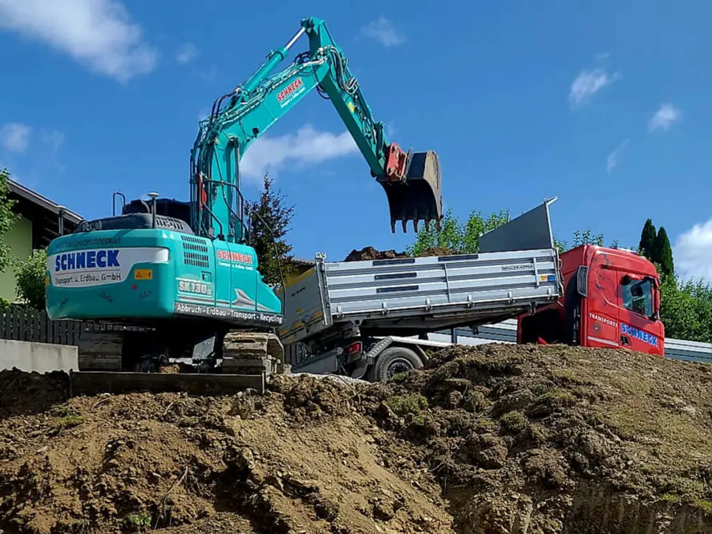 Verladung von Erdmaterial auf einen LKW bei laufenden Aushubarbeiten.