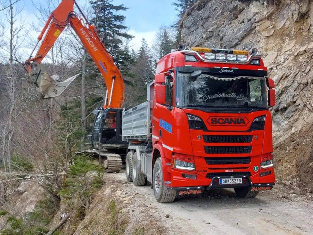 Materialverladung mit Bagger und LKW beim Forststraßenbau.