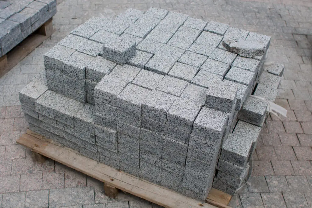Palette mit geschnittenen Granitpflastersteinen in verschiedenen Formaten für Wege-, Hof- und Pflasterflächen.