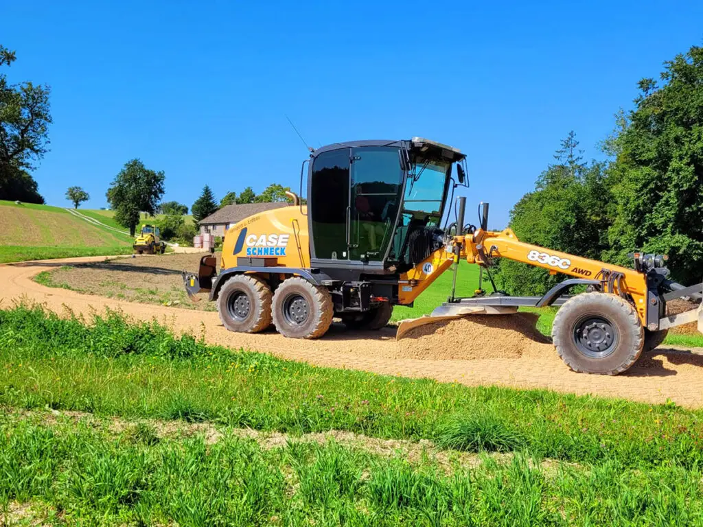 Motorgrader bei der Herstellung eines ebenen Untergrunds für Verkehrs- und Bauflächen.