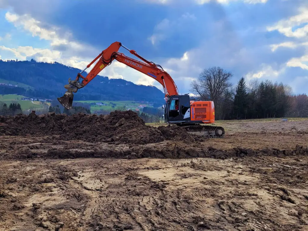 Bagger bei der Geländemodellierung und Vorbereitung einer Baustelle.