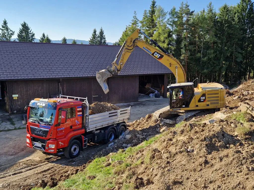 Bagger- und LKW-Arbeiten beim Wegebau und der Geländeprofilierung.