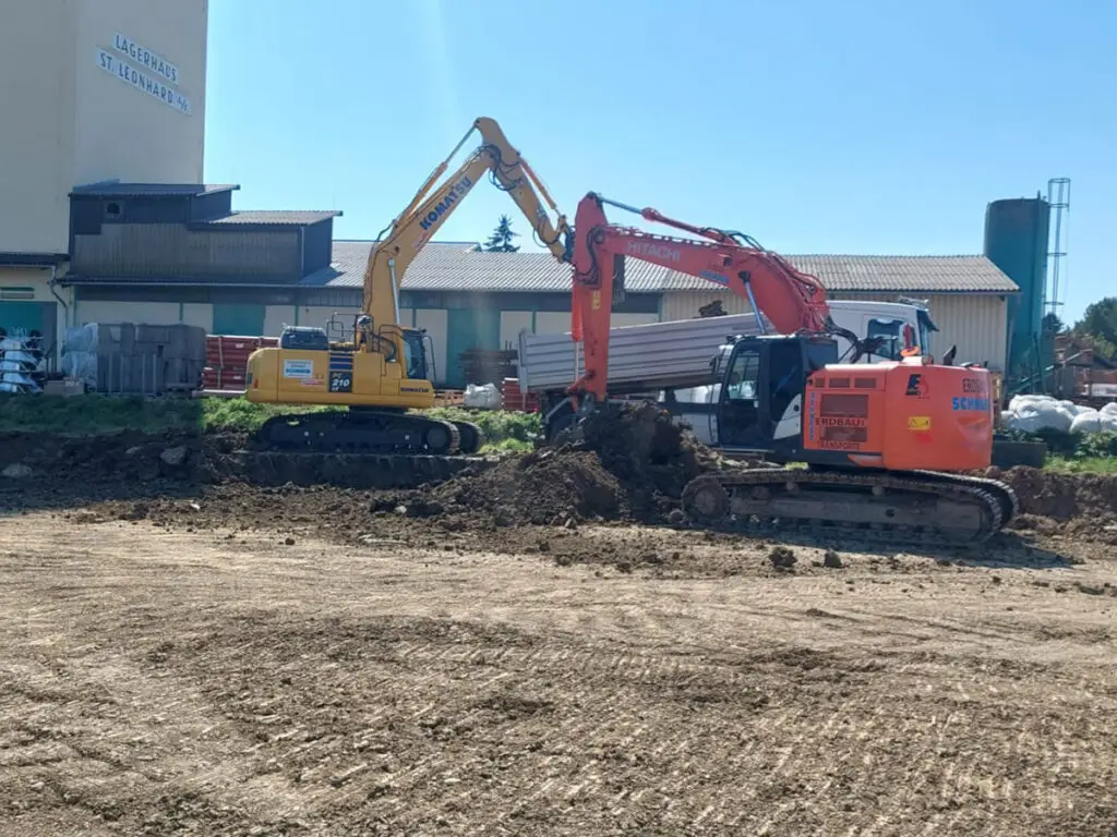 Baustelle im Straßen- und Wegebau mit mehreren Baggern bei Erdarbeiten.