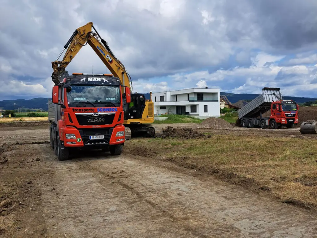 LKW und Bagger bei Erdarbeiten für den Straßen- und Wegebau.