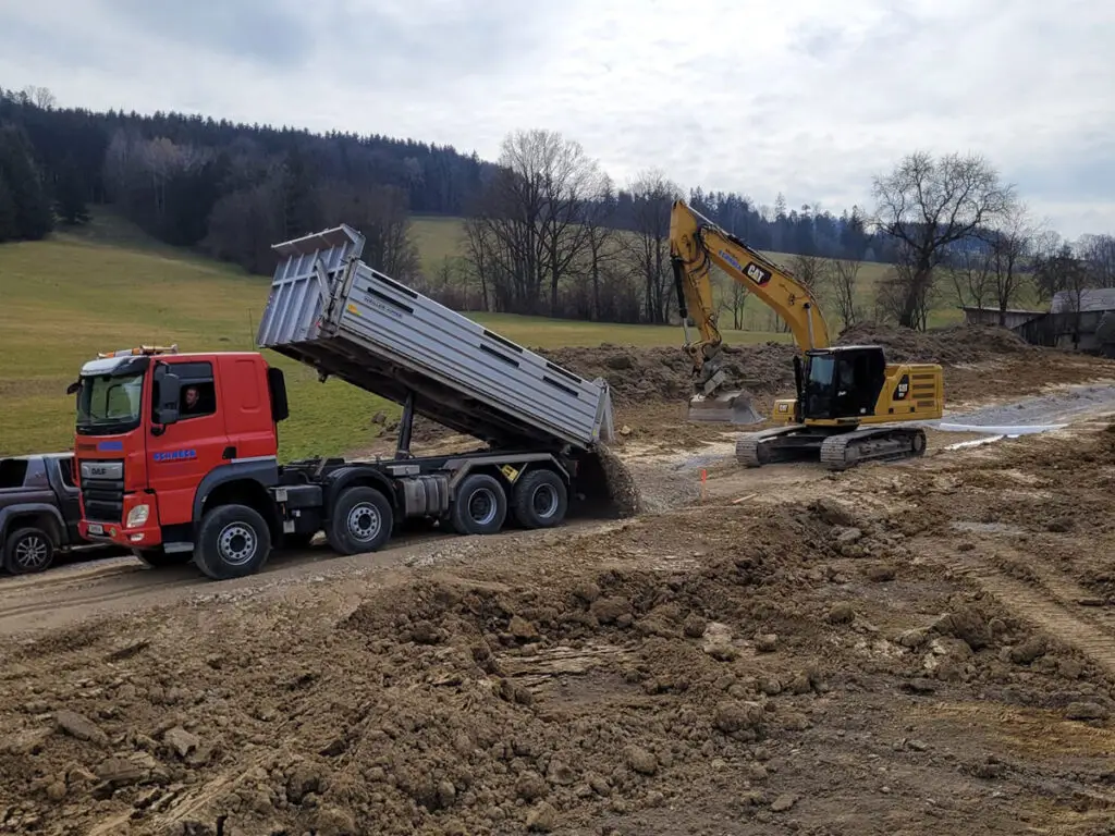 Materialtransport und Geländemodellierung für den Neubau eines Fahrweges.